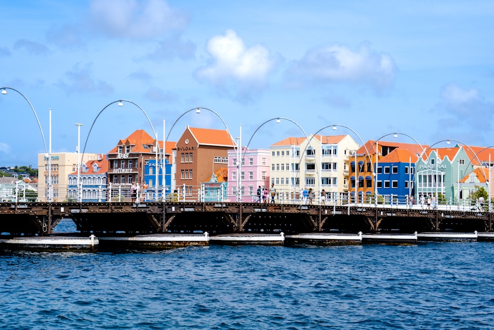 a bridge over a body of water with buildings in the background