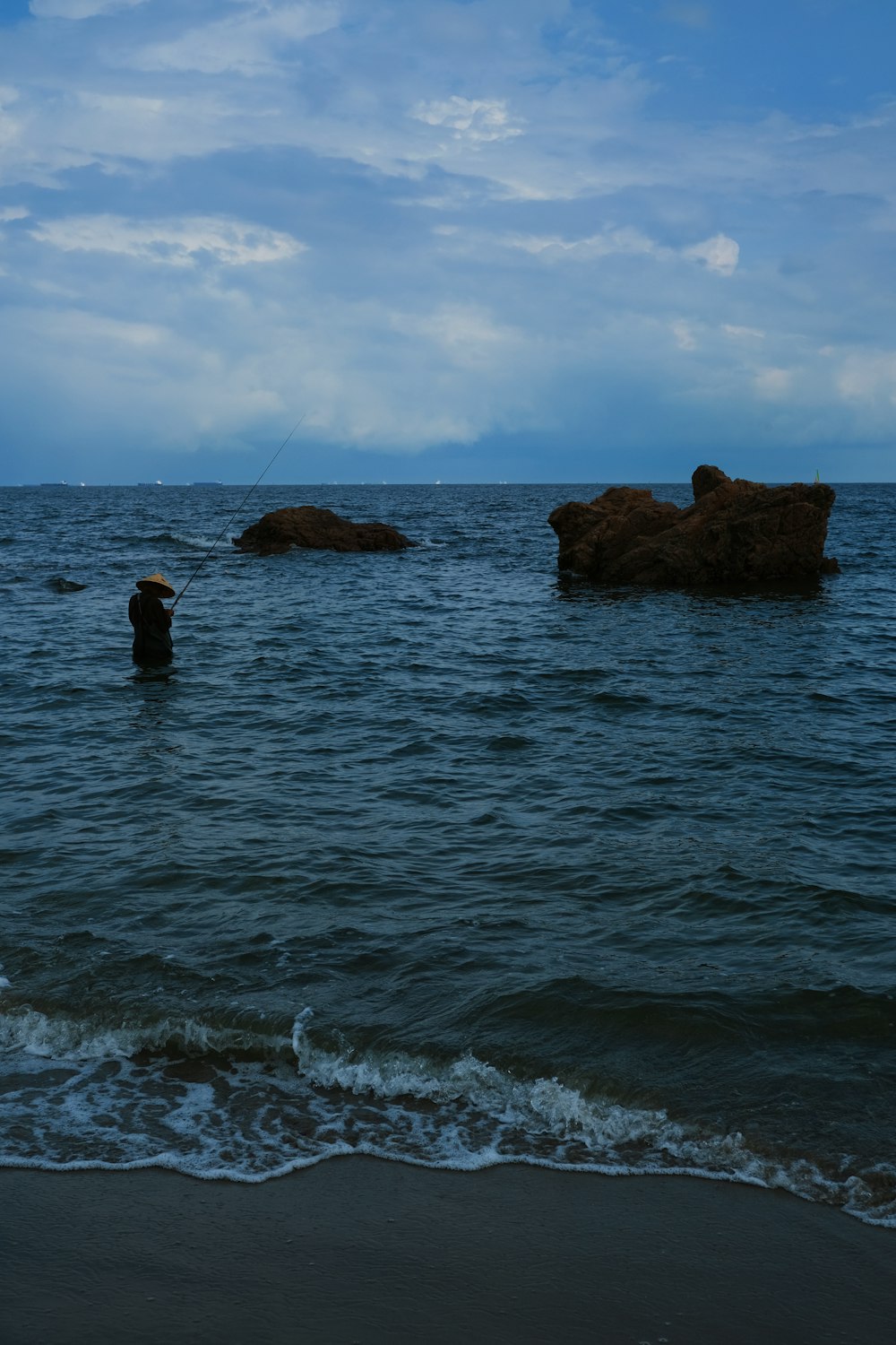 Eine Person, die mit einem Regenschirm im Meer watet