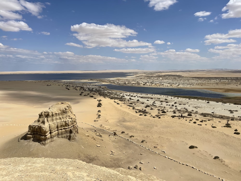 an aerial view of a desert with a body of water