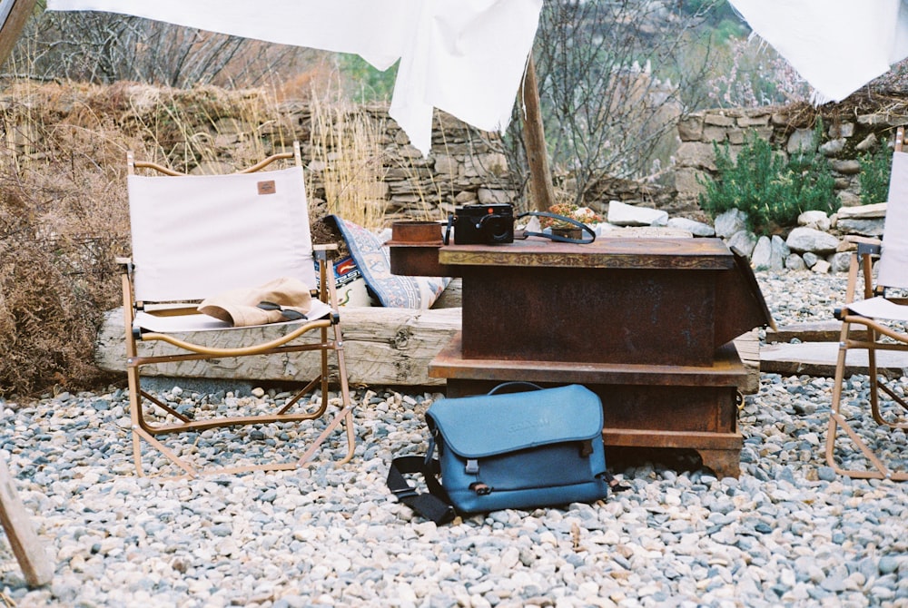 a couple of chairs sitting on top of a gravel field