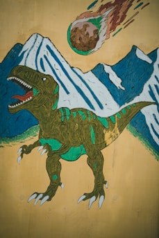 A stylized mural features a green dinosaur with an open mouth in front of snow-capped mountains. Above, a flaming meteor hurtles through the sky. The colors are vivid, with the dinosaur showing detailed textures and shading.
