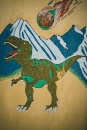 A stylized mural features a green dinosaur with an open mouth in front of snow-capped mountains. Above, a flaming meteor hurtles through the sky. The colors are vivid, with the dinosaur showing detailed textures and shading.