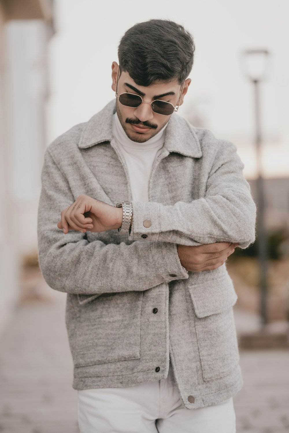 a man with a moustache wearing sunglasses and a jacket