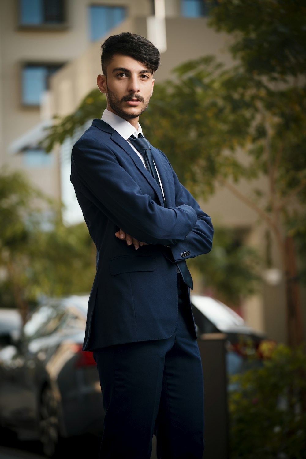 a man in a suit standing in front of a building