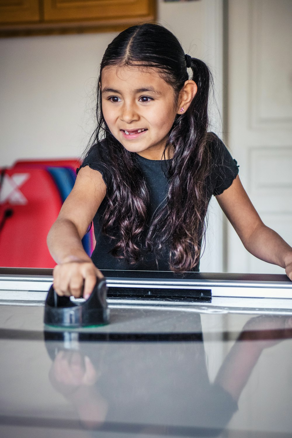 a little girl standing at a table with a mouse