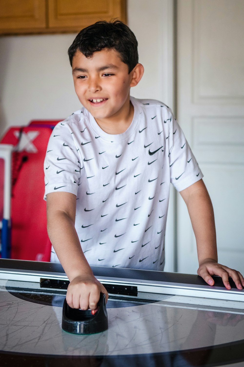 a young boy standing at a table with a computer mouse