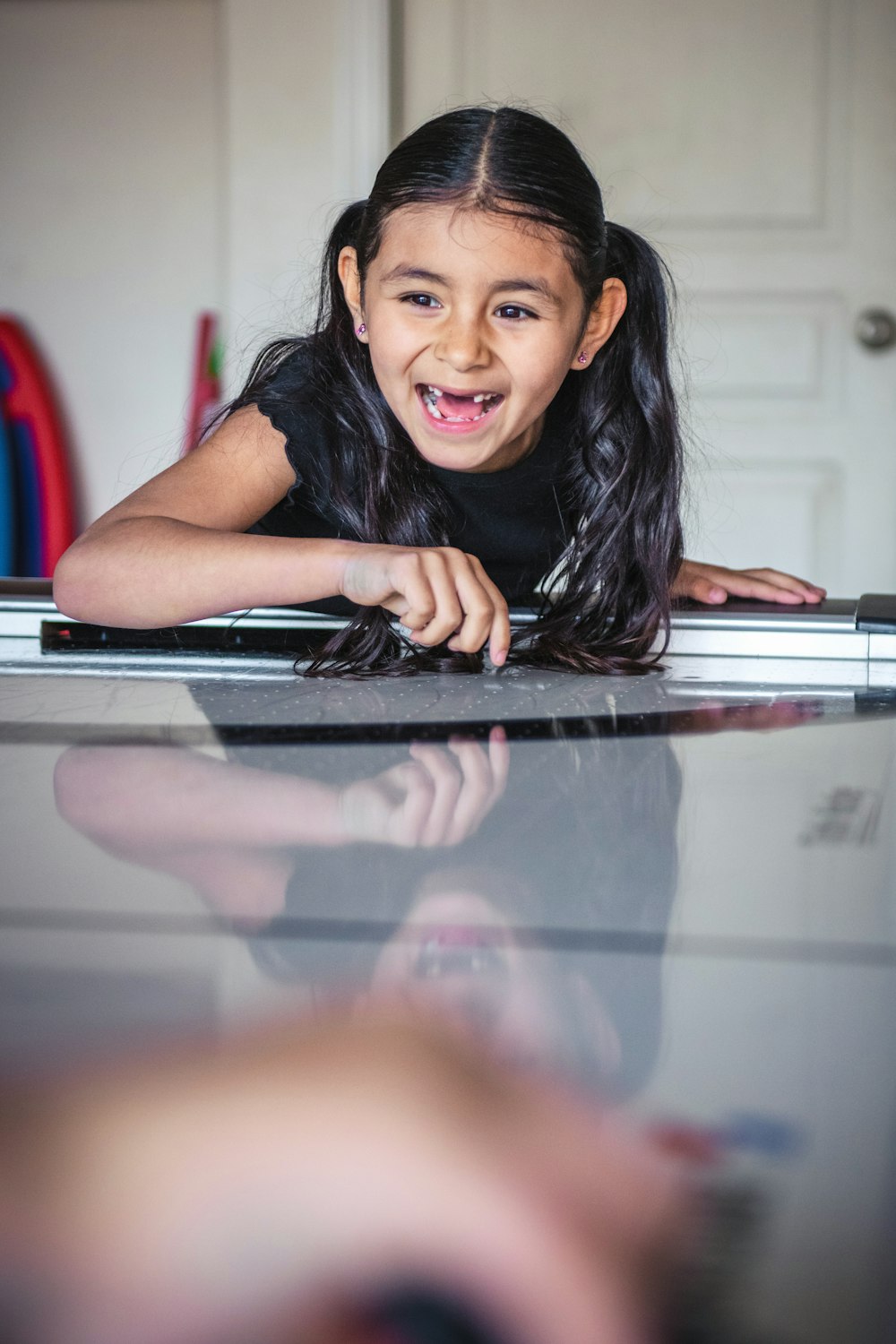 a little girl laying on top of a piano
