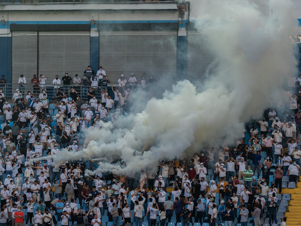 a crowd of people standing around a smoke bomb