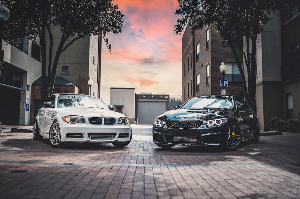 two cars parked next to each other on a brick road