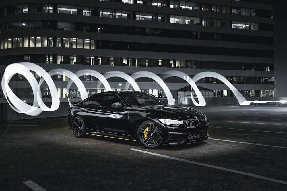 a black car parked in front of a tall building