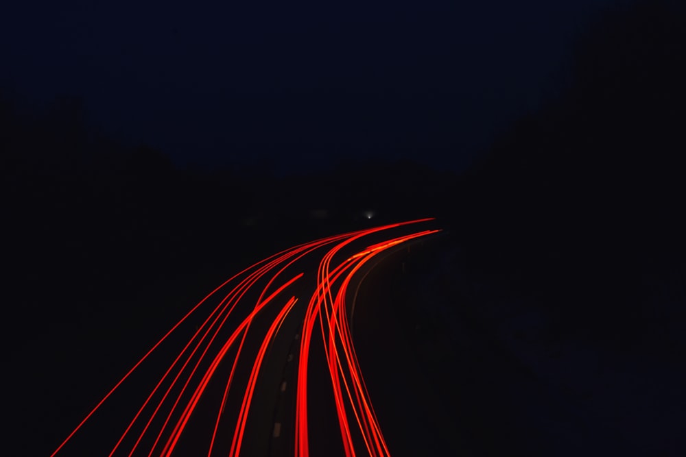 a long exposure photo of a highway at night