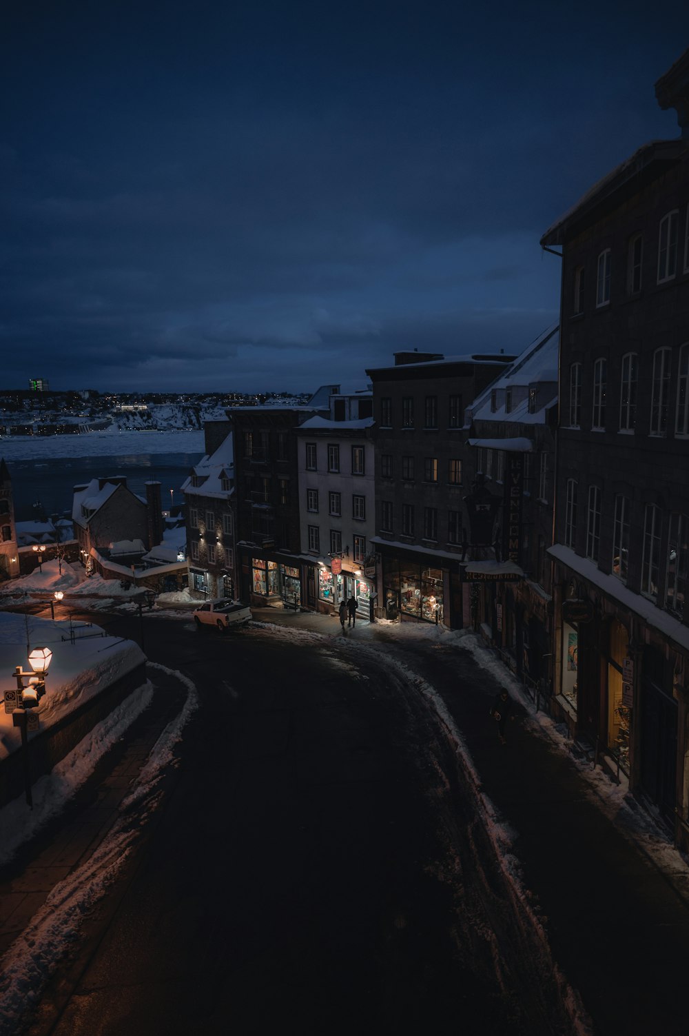 a city street at night with snow on the ground