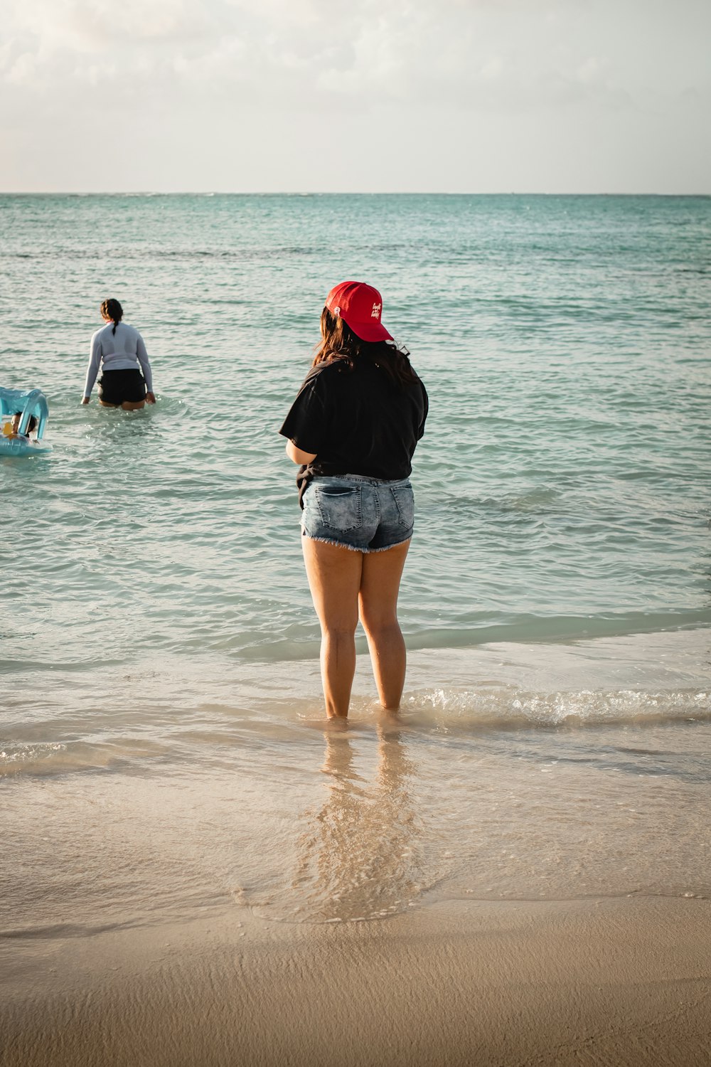 a woman standing in the water at the beach