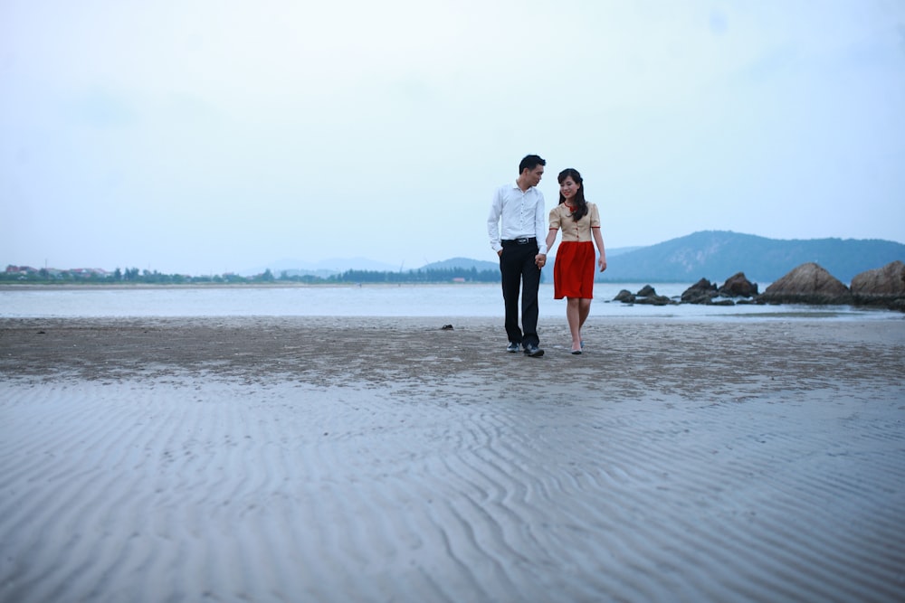 a man and a woman walking on a beach
