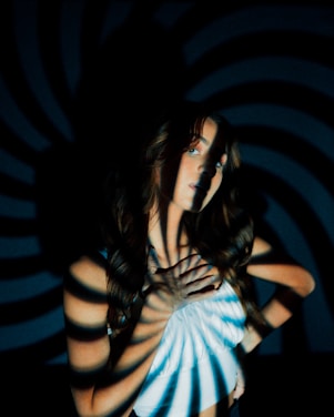 a woman standing in front of a black and white wall