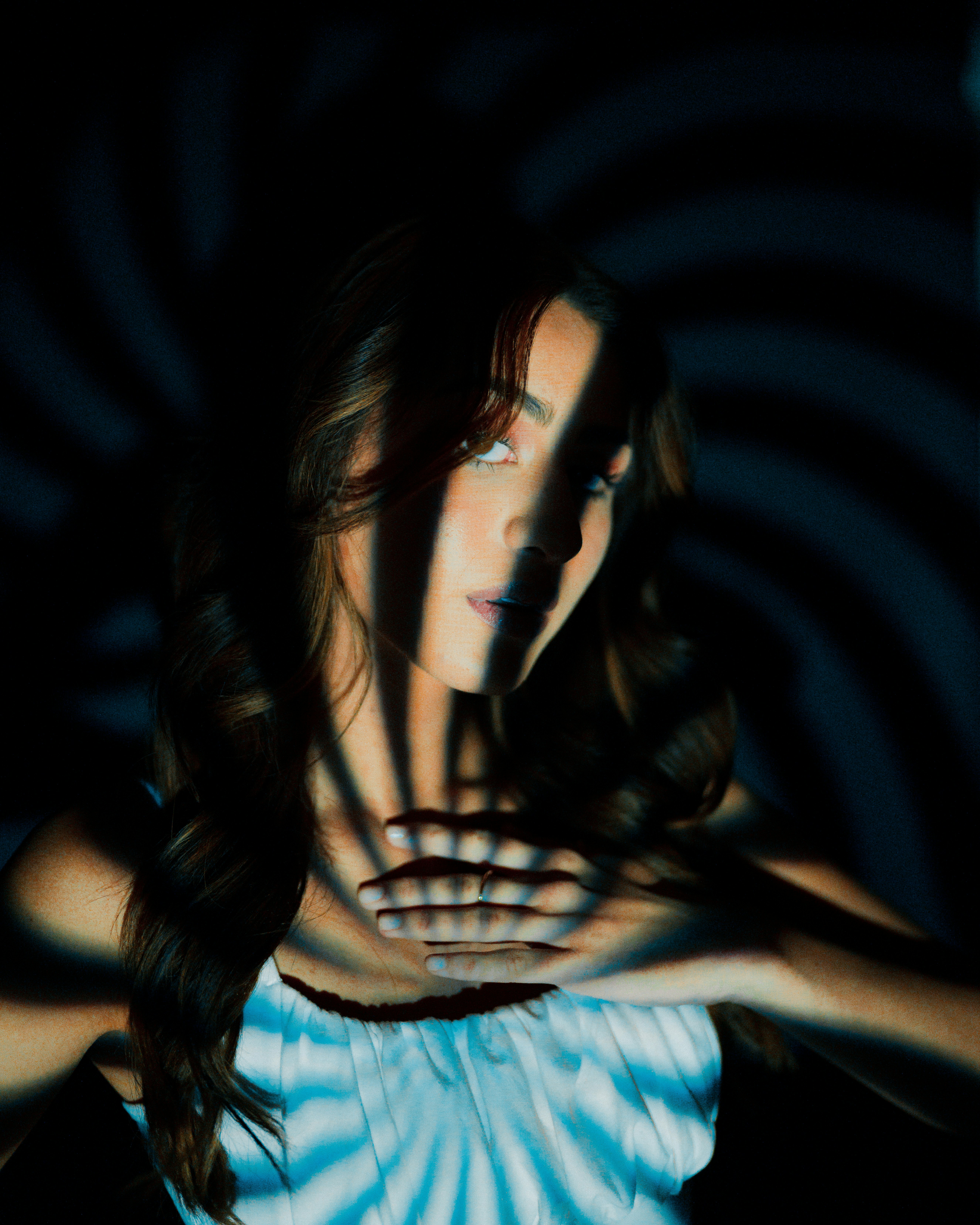 a woman in a blue and white dress holding her hands out in front of her
