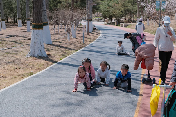 A group of smiling babies engaged in a guided crawling workshop with attentive instructors.