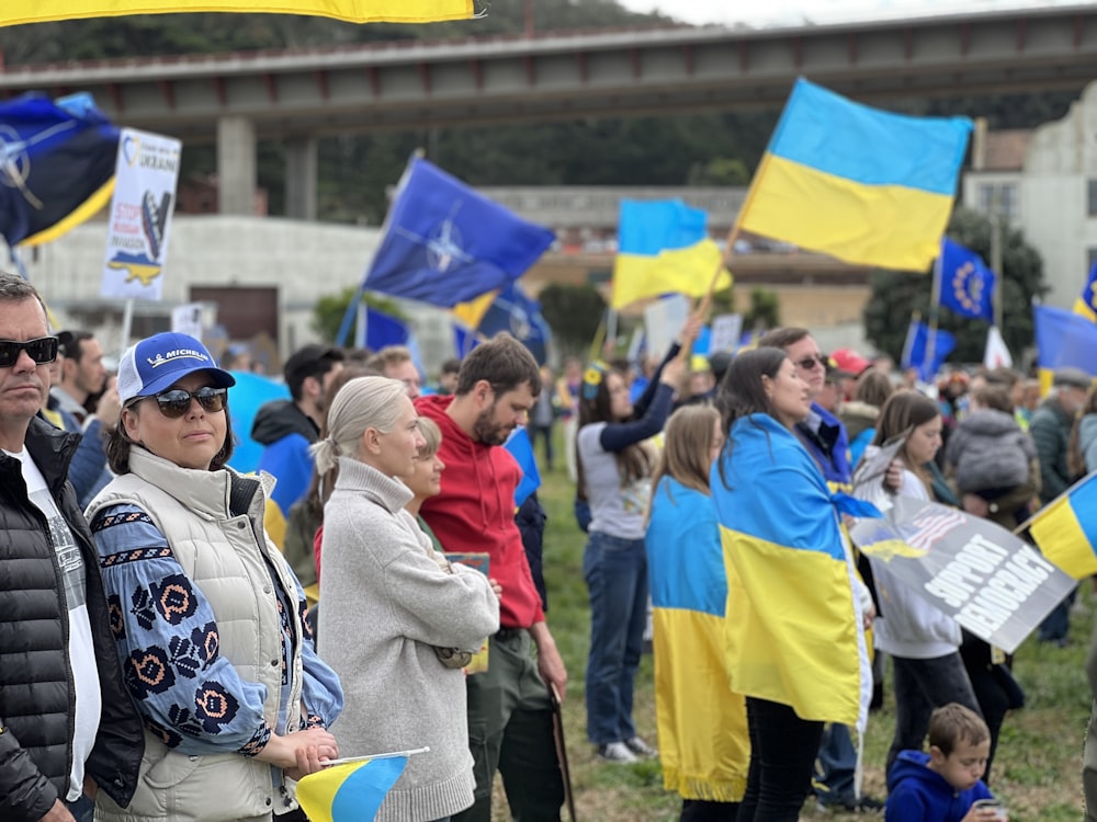 a group of people standing in a field holding flags