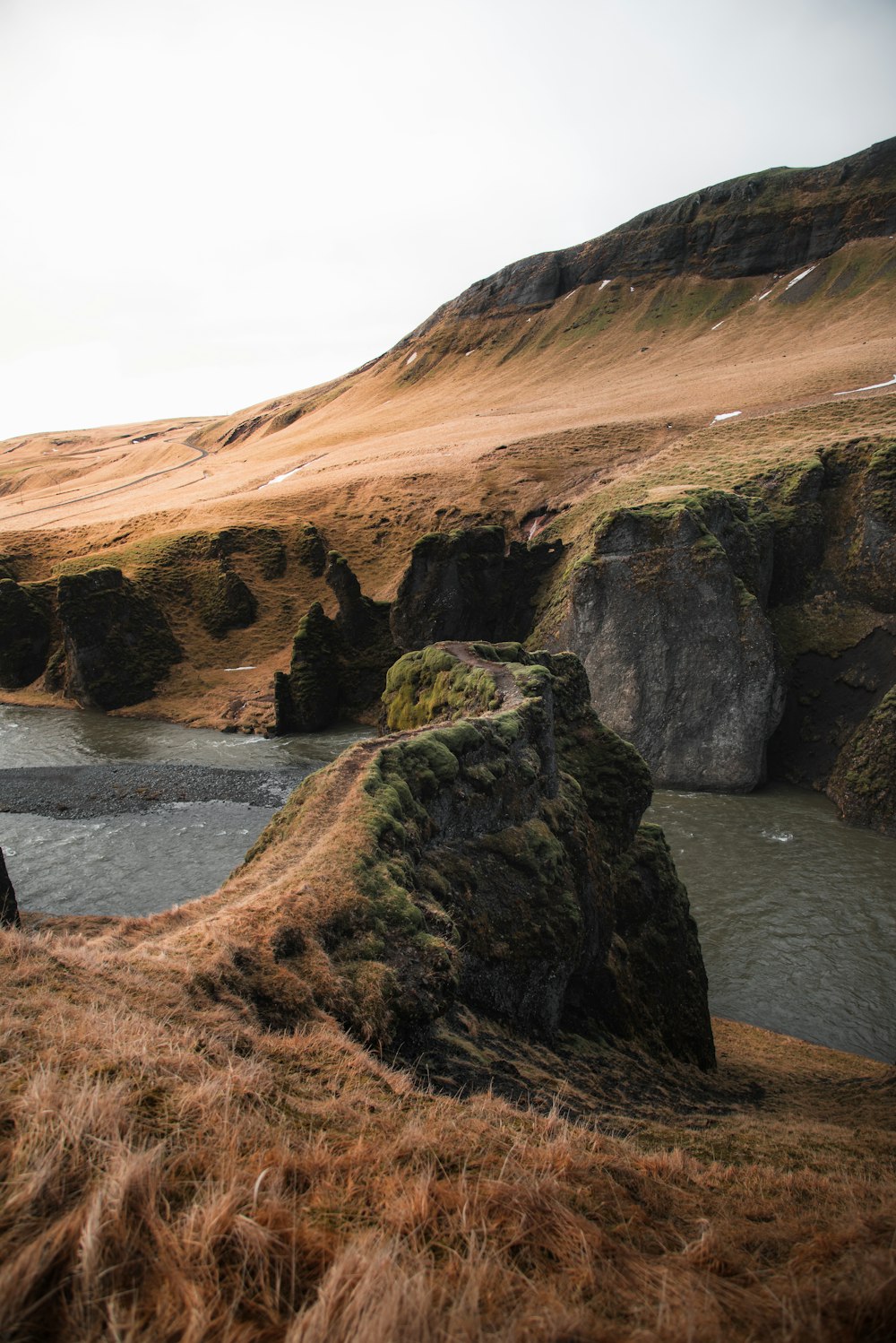 a man standing on top of a hill next to a river