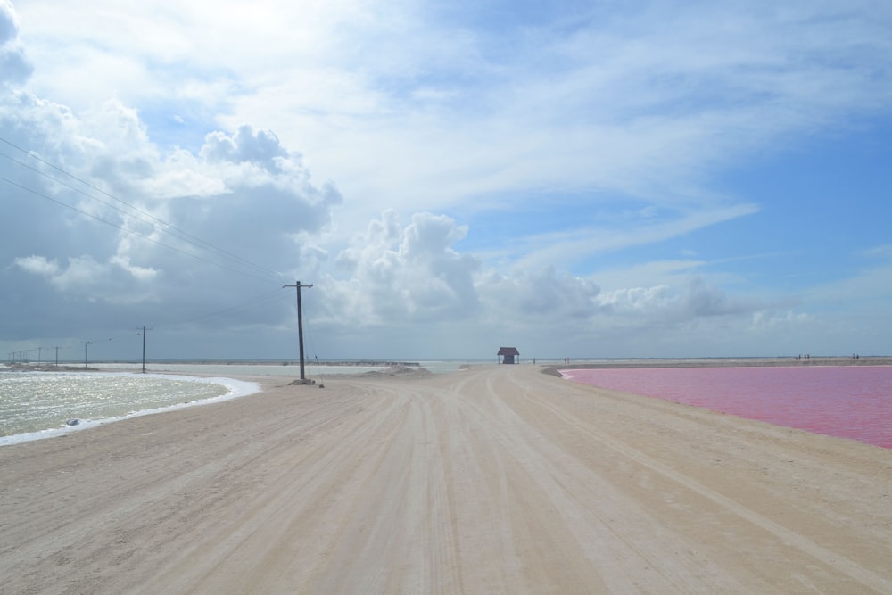 a dirt road next to a body of water