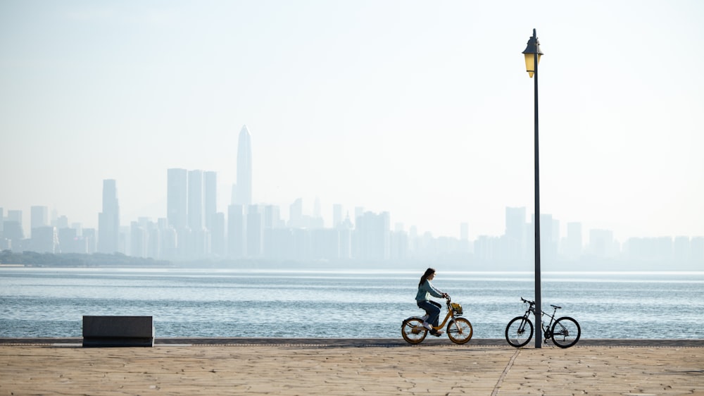 a person riding a bike next to a body of water