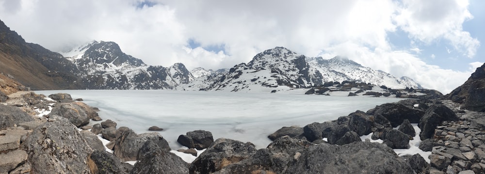 a snow covered mountain range with rocks and snow