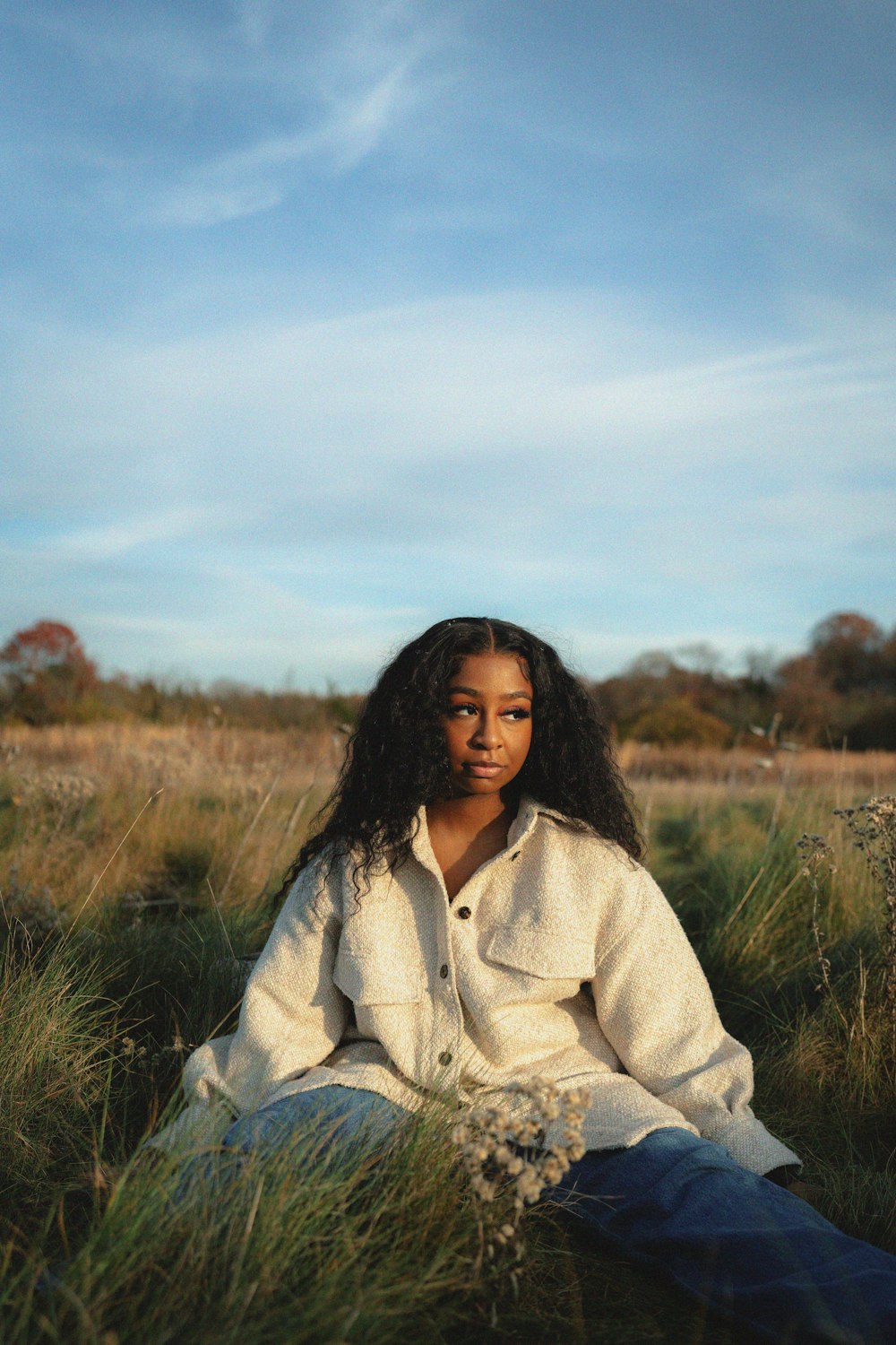 a woman sitting in a field of tall grass