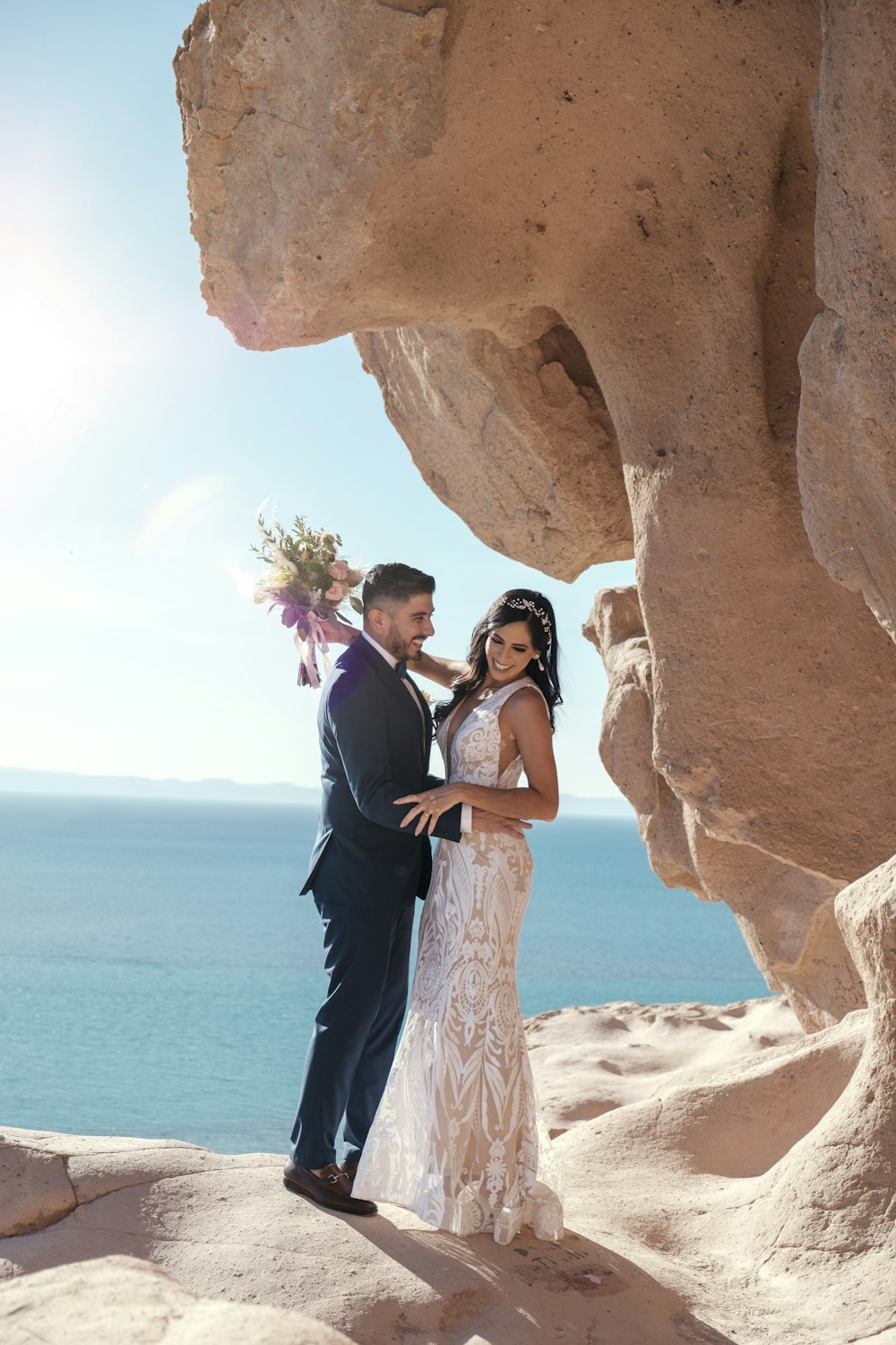 a bride and groom pose for a photo in the desert