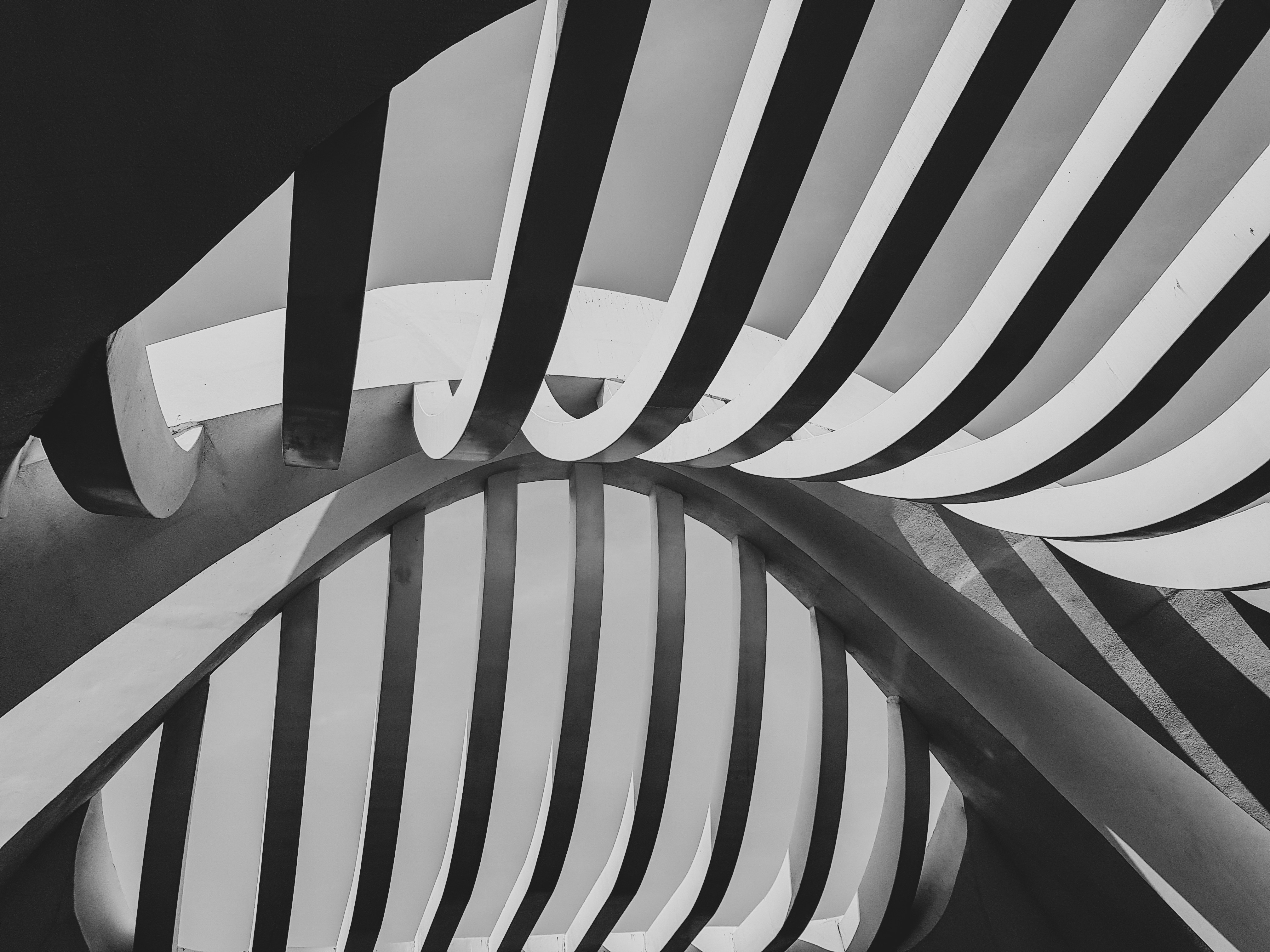 a black and white photo of a curved building