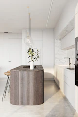 Modern kitchen island illuminated by sleek pendant lamps with natural wood accents.