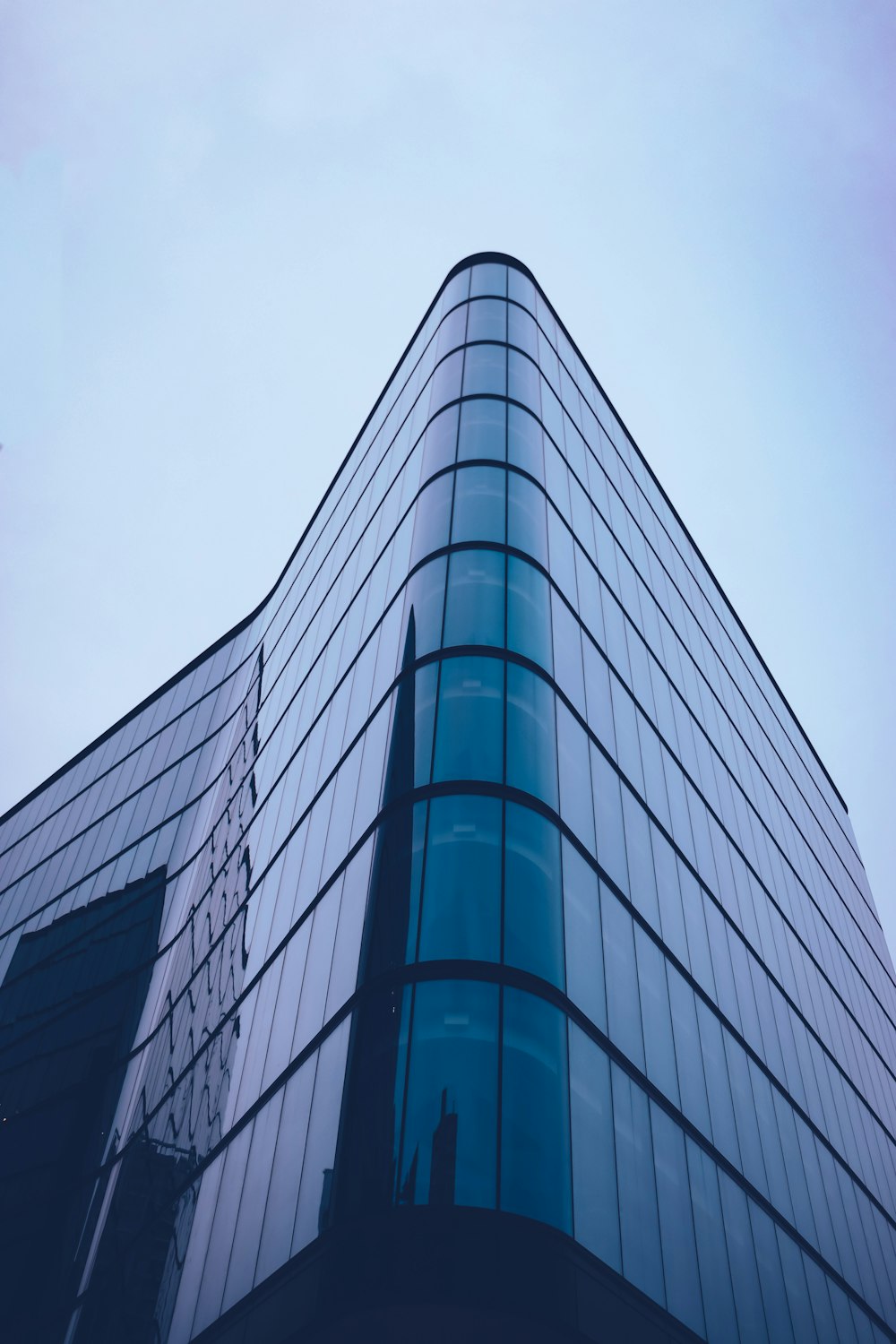 a tall glass building with a sky background