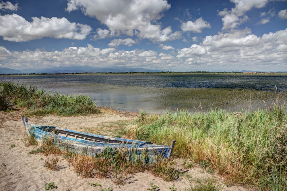 a boat on the shore of a lake