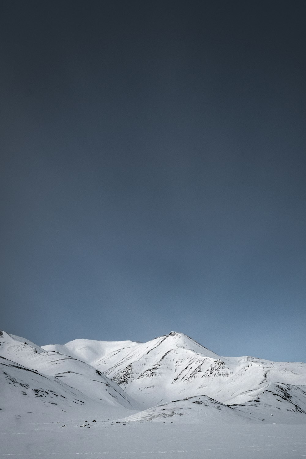 a snowy mountain with a blue sky