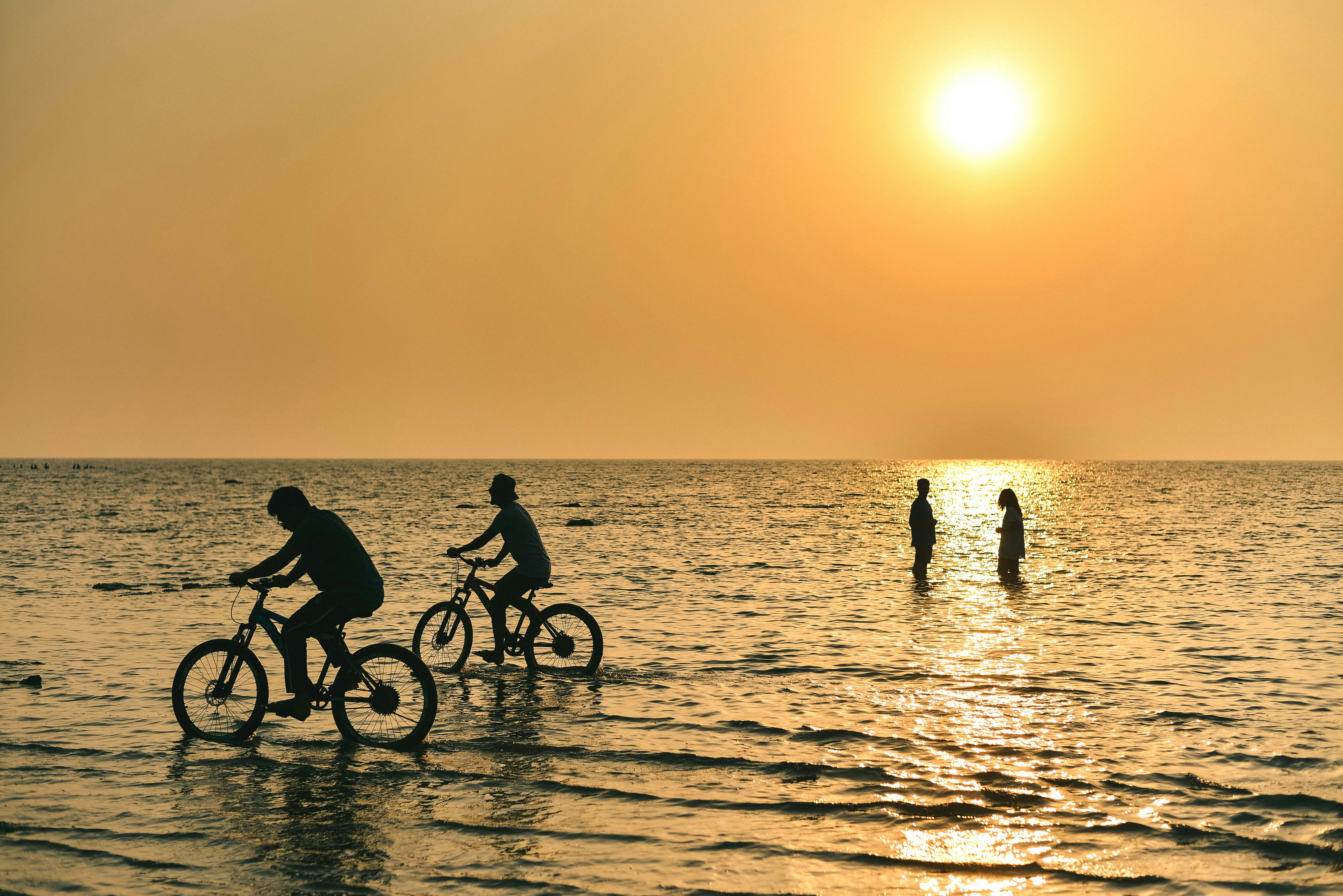 a group of people riding bikes in the water