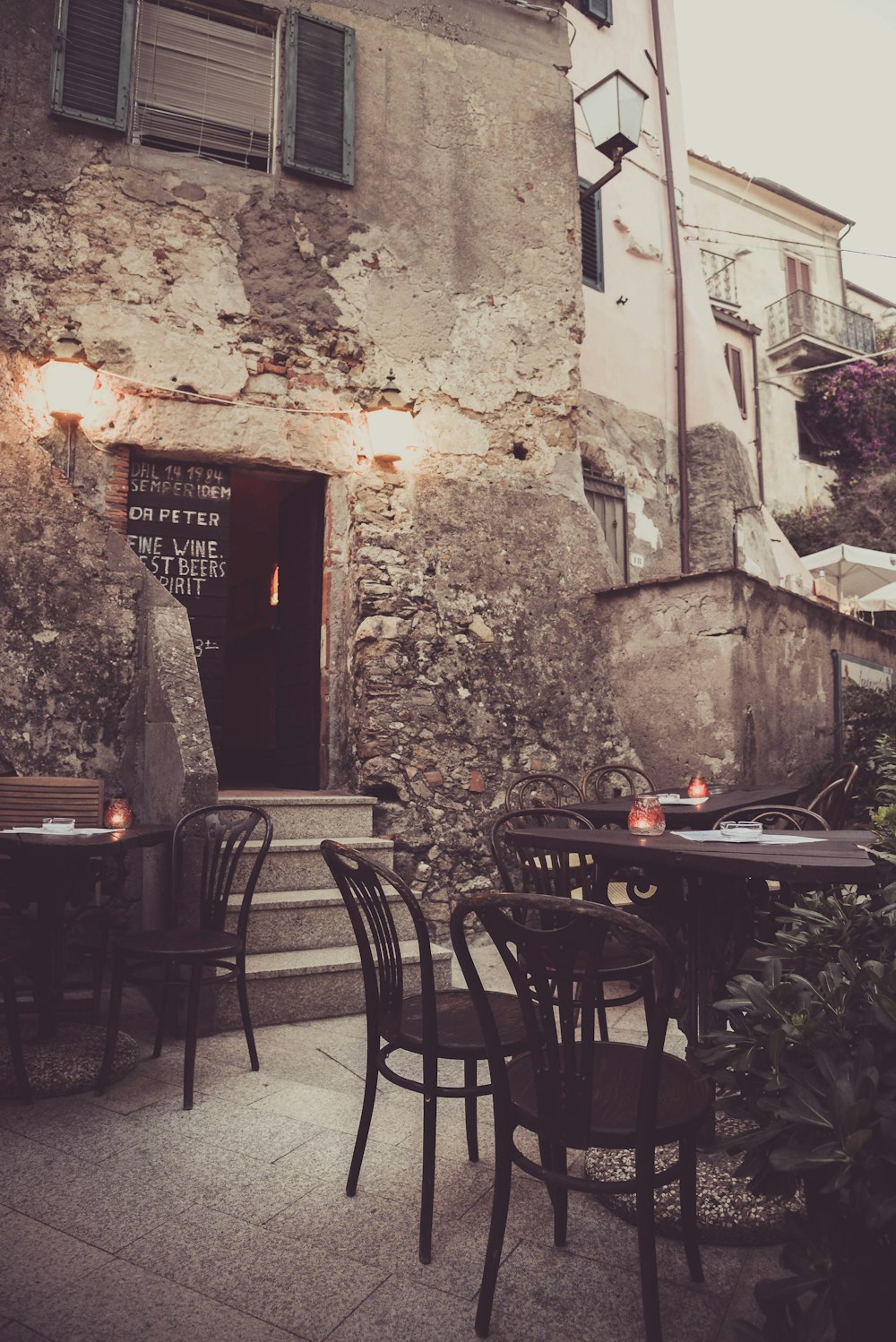 a stone building with tables and chairs