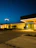 A well-lit commercial parking lot at dusk with clear, bright exterior lighting.