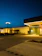 A well-lit commercial parking lot at dusk with clear, bright exterior lighting.