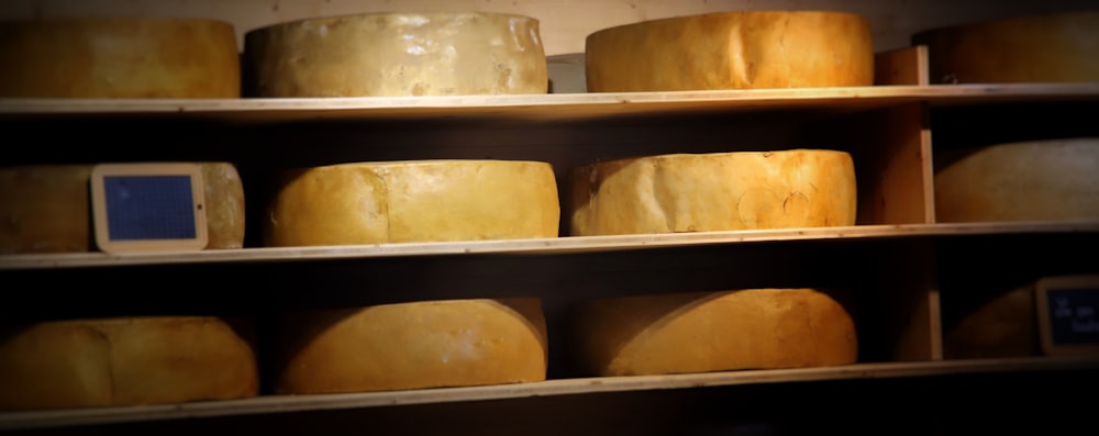 a group of cheeses on a shelf