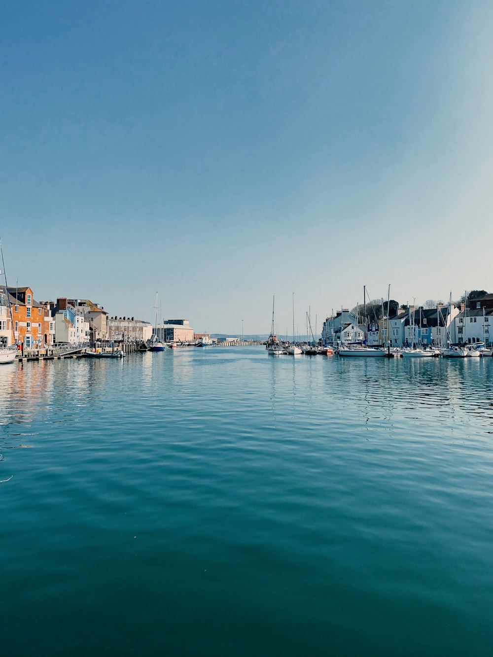 a body of water with boats in it and buildings in the back