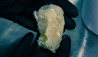 Close-up of hands holding semi-processed energy materials, highlighting texture and quality.