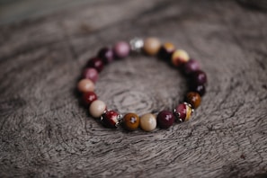 Silver rhodium bracelet featuring a blend of silver and golden hues on a polished wooden surface
