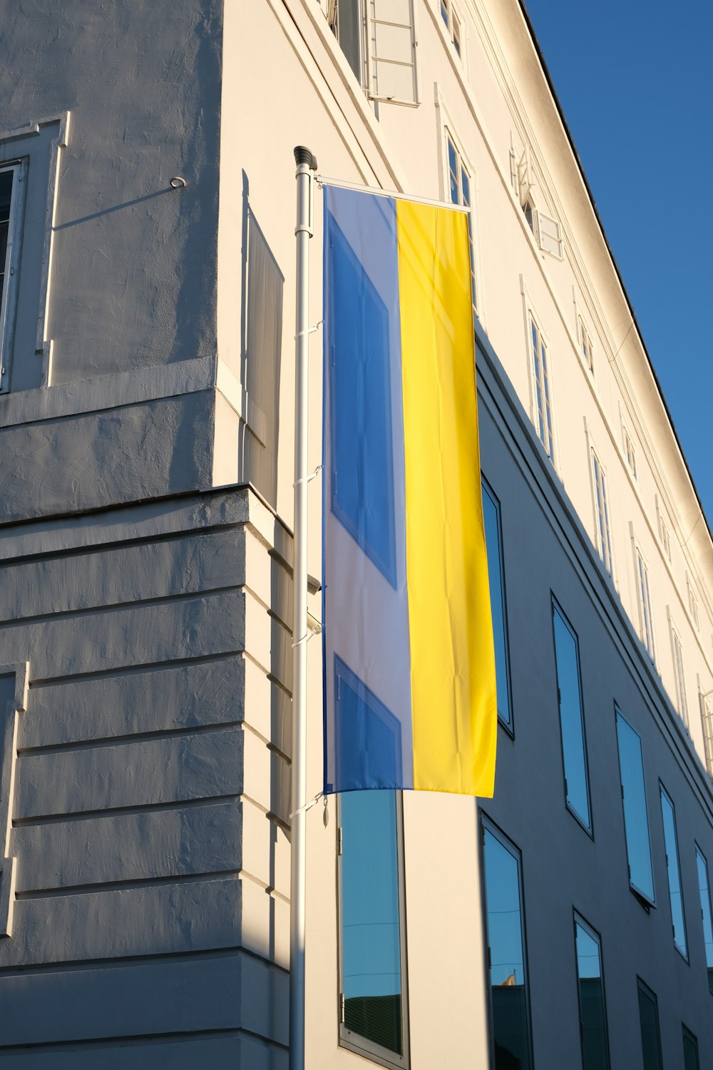 Un edificio con una bandera amarilla y azul en el lateral
