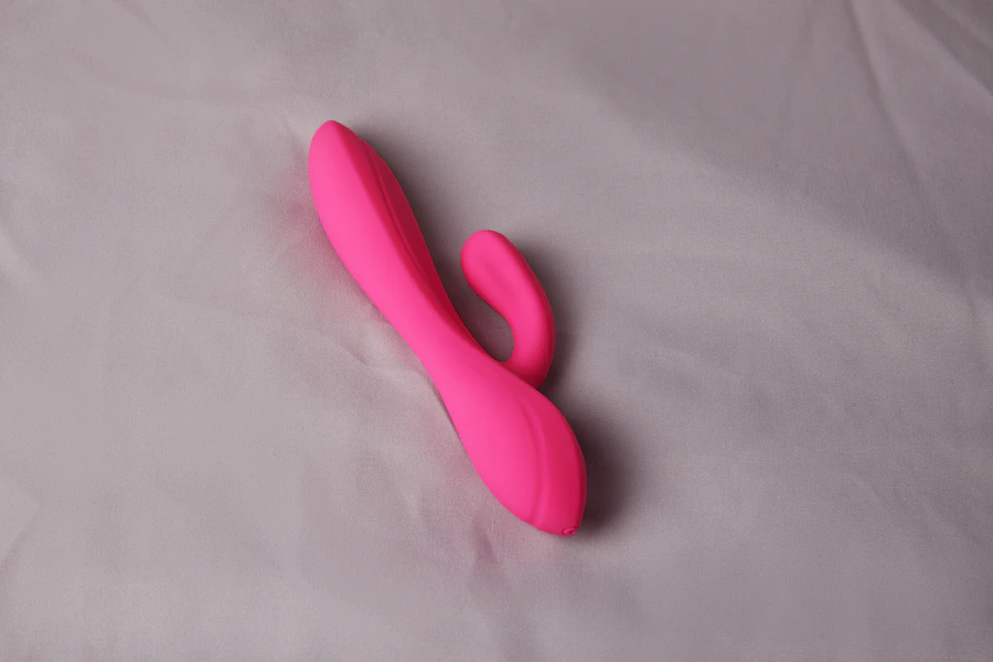Pink rabbit-style massager on a grey surface