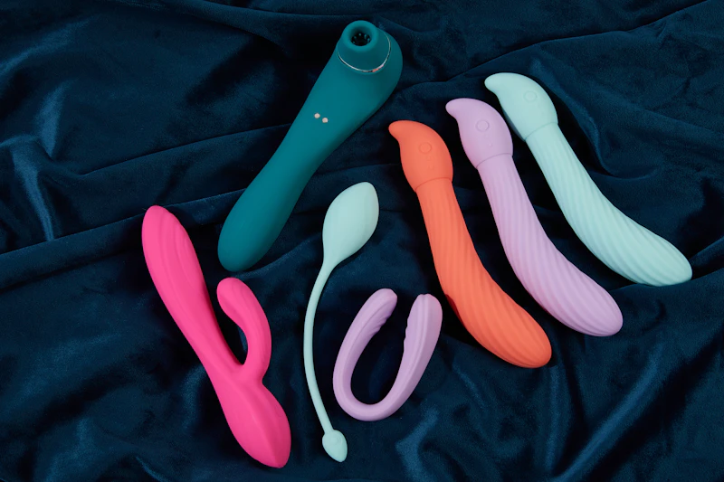 Assorted colourful personal massagers on dark velvet
