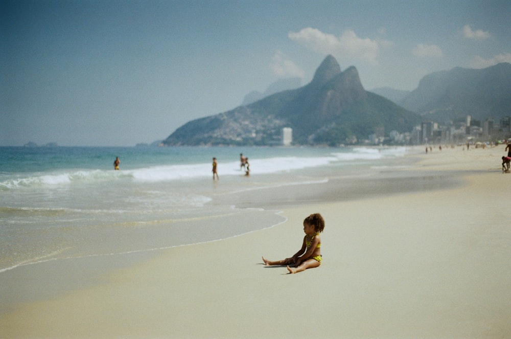 a person sitting on a beach with Ipanema in the background