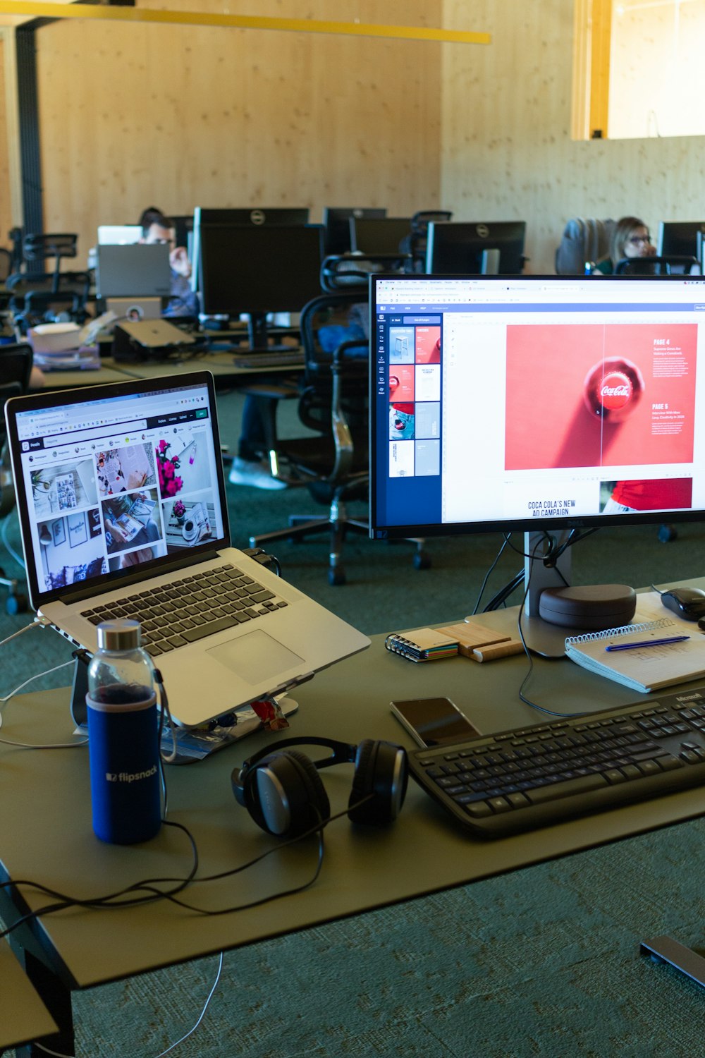 a desk with computers and a laptop