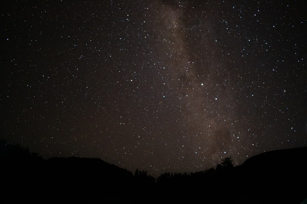 a starry night sky over a mountain range