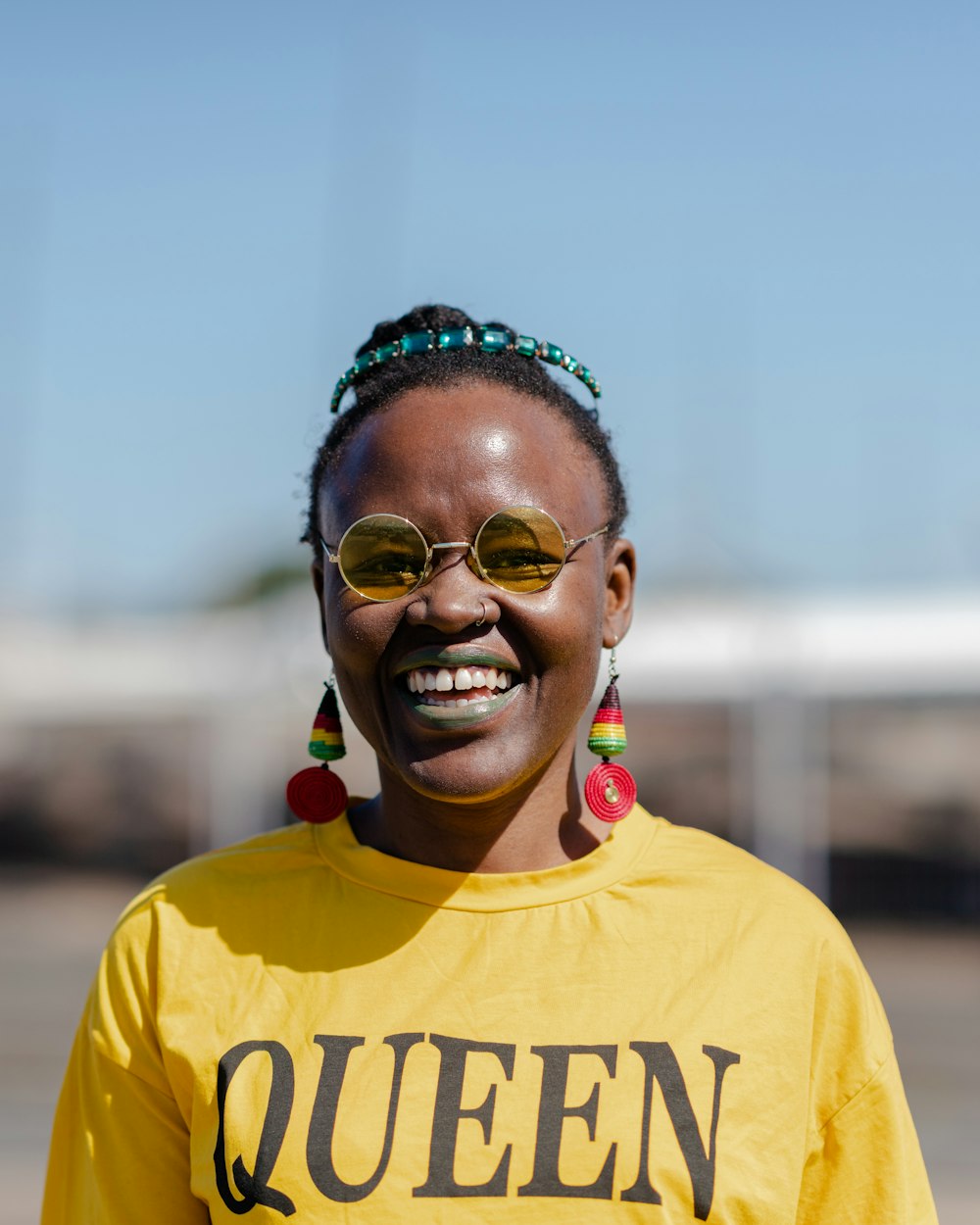 a man wearing sunglasses and a yellow shirt with a red and blue crown