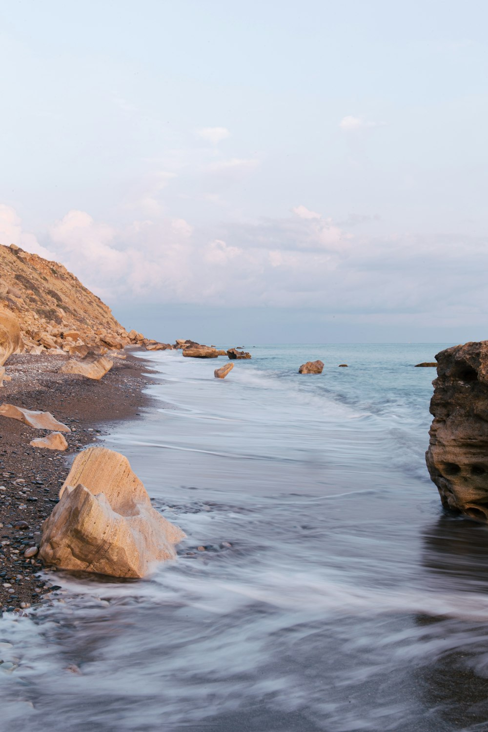 a body of water with rocks and a beach