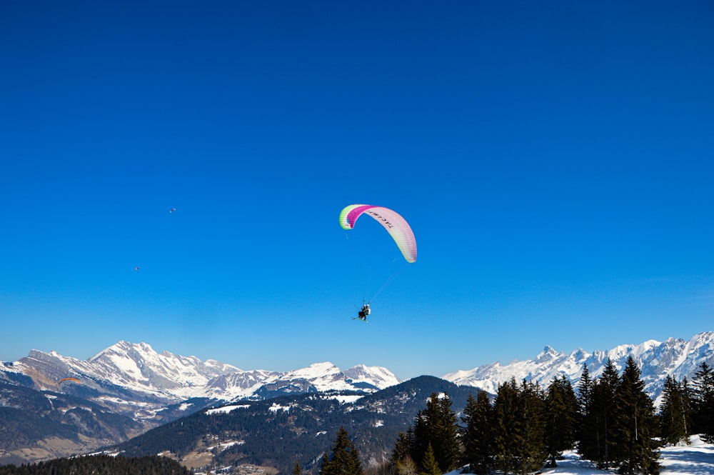 a man flying through the air on a snow covered mountain